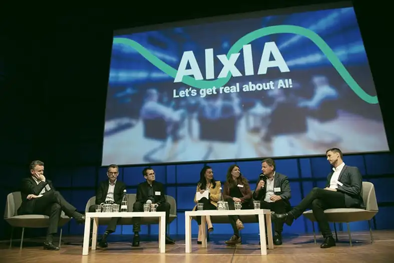 Menschen auf der Bühne: Paneldiskussion bei der AIxIA in Karlsruhe. Bild: DIZ | Digitales Innovationszentrum, aixia.eu