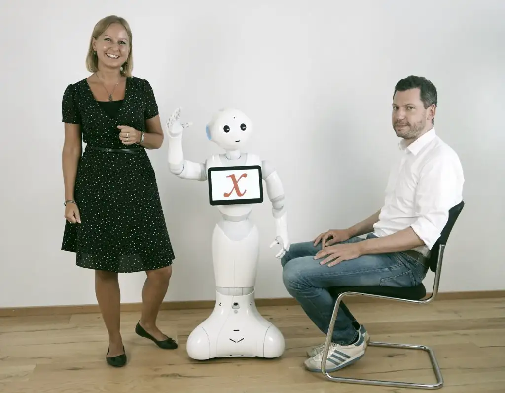 Das Team "Creative Collections" des Badischen Landesmuseum posiert mit dem Roboter Xaver, auf dessen Display das "x" des "museum x"-Schriftzugs angezeigt wird