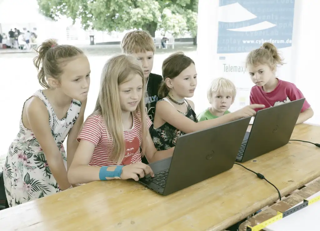 Mehrere Kinder arbeiten interessiert an zwei Laptops.
Bild: EFFEKTE, Jürgen Rösner