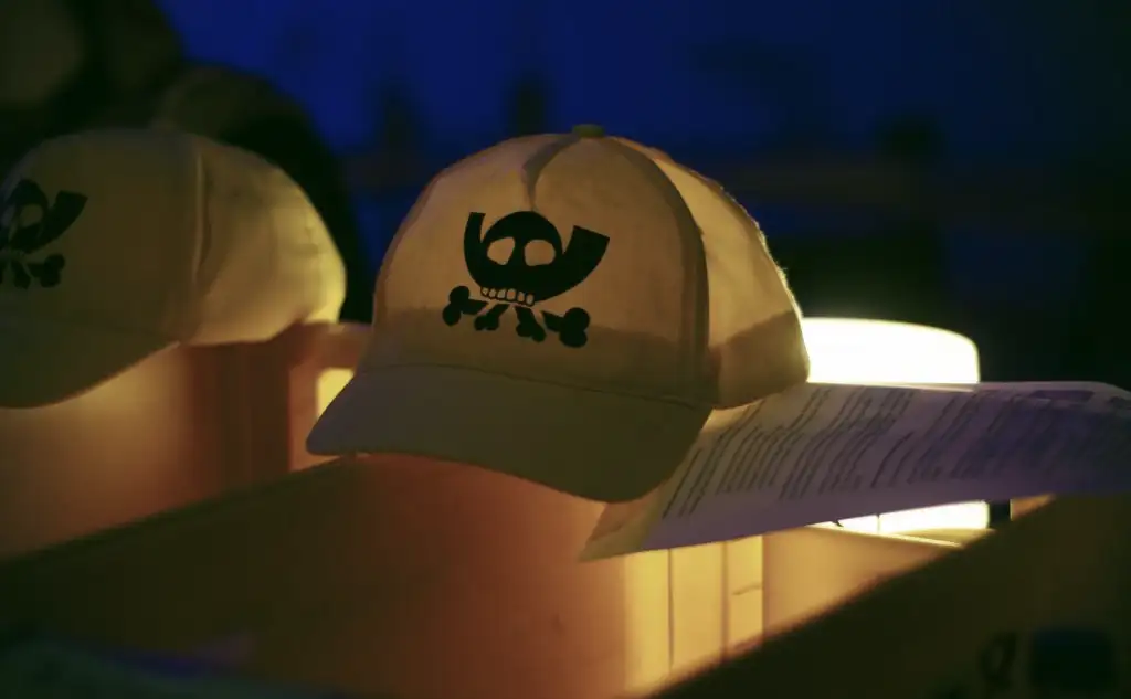 Zwei gelbe Mützen, die von hinten beleuchtet sind. Auf den Mützen ist das sogenannte Pesthörnchen gedruckt, das Logo des CCC. Bild: @ElektrollArt