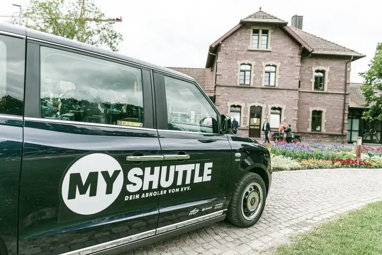 Ein schwarzer KVV Shuttle vor einem Haus